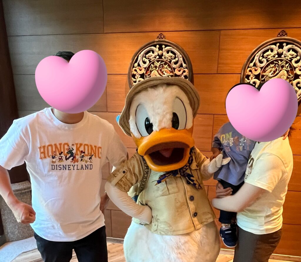 キャラクターと記念撮影する観光客家族